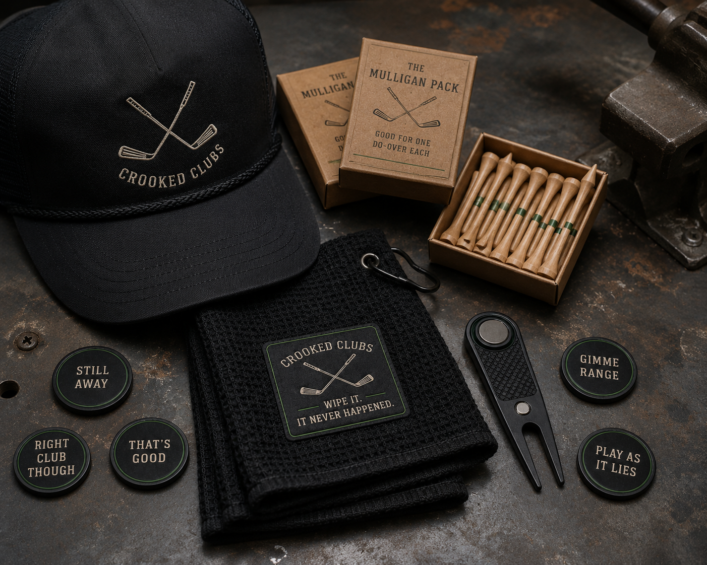 The full Crooked Clubs lineup laid out: rope hat, ball markers, divot tool, Mulligan Pack tees, and waffle towel